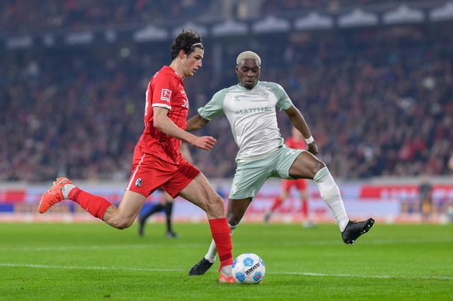 Freiburg's Merlin Röhl takes on Werder Bremen's Derrick Köhn.