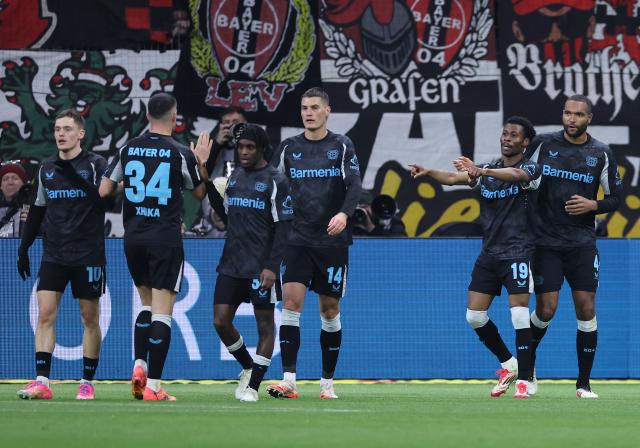 Bayer Leverkusen players celebrate Nathan Tella's opener against Eintracht Frankfurt. 