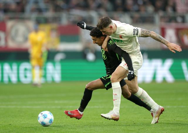 Augsburg's Cédric Zesiger and Wolfsburg's Tiago Tomás contest for the ball, 15. March 2025.